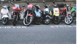 Variety of motorcycles, mopeds and scooters in motorcycle parking area
