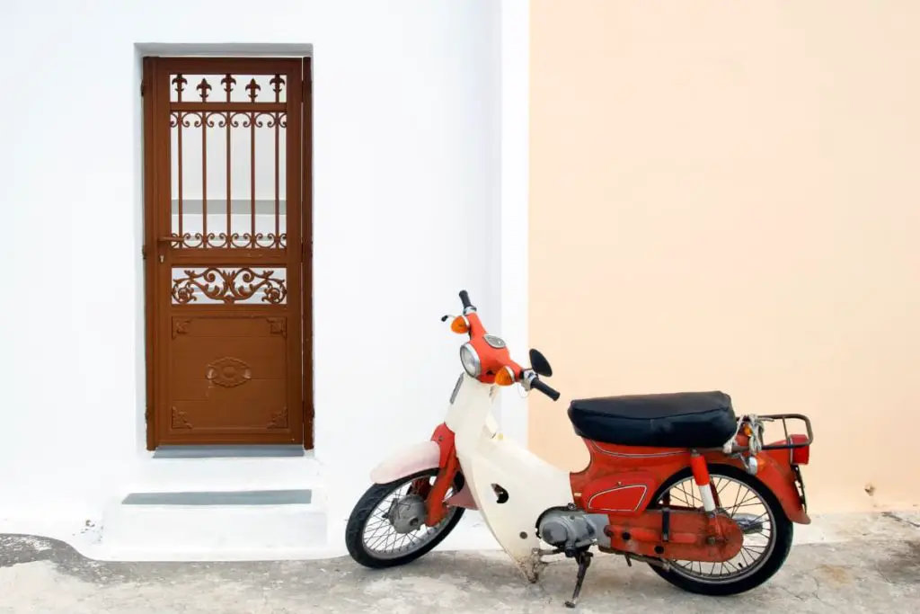 moped with pedals and a motor on a kickstand