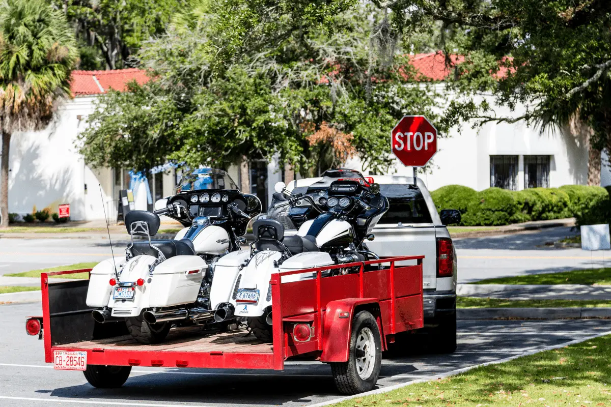 motorcycles loaded into a trailer pulled by a truck