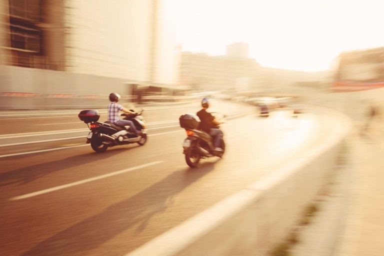 2 scooters riding at high speeds at their max to catch up to scooters in the distance