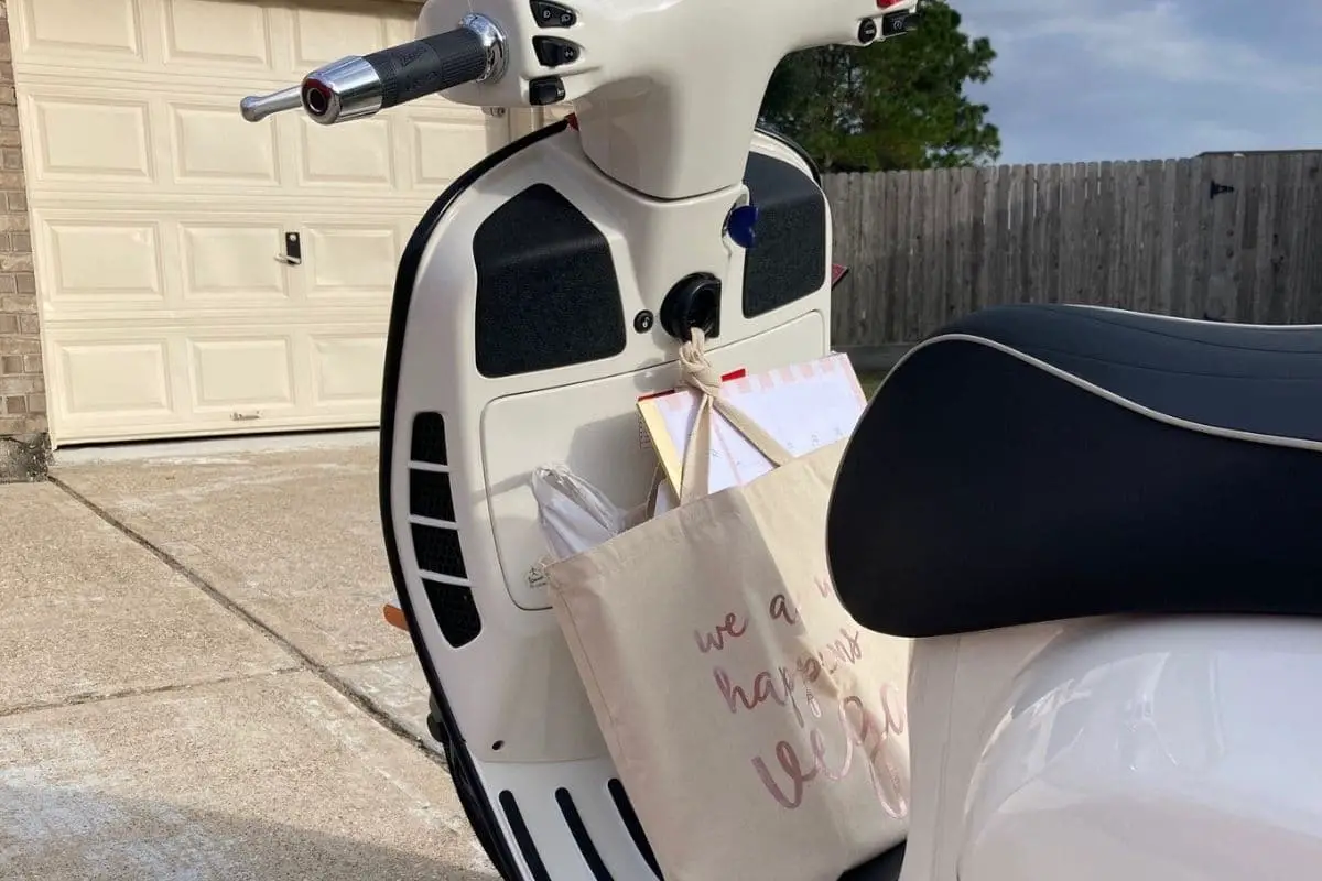 Vespa GTS parked with a bag hanging on the hook for extra storage