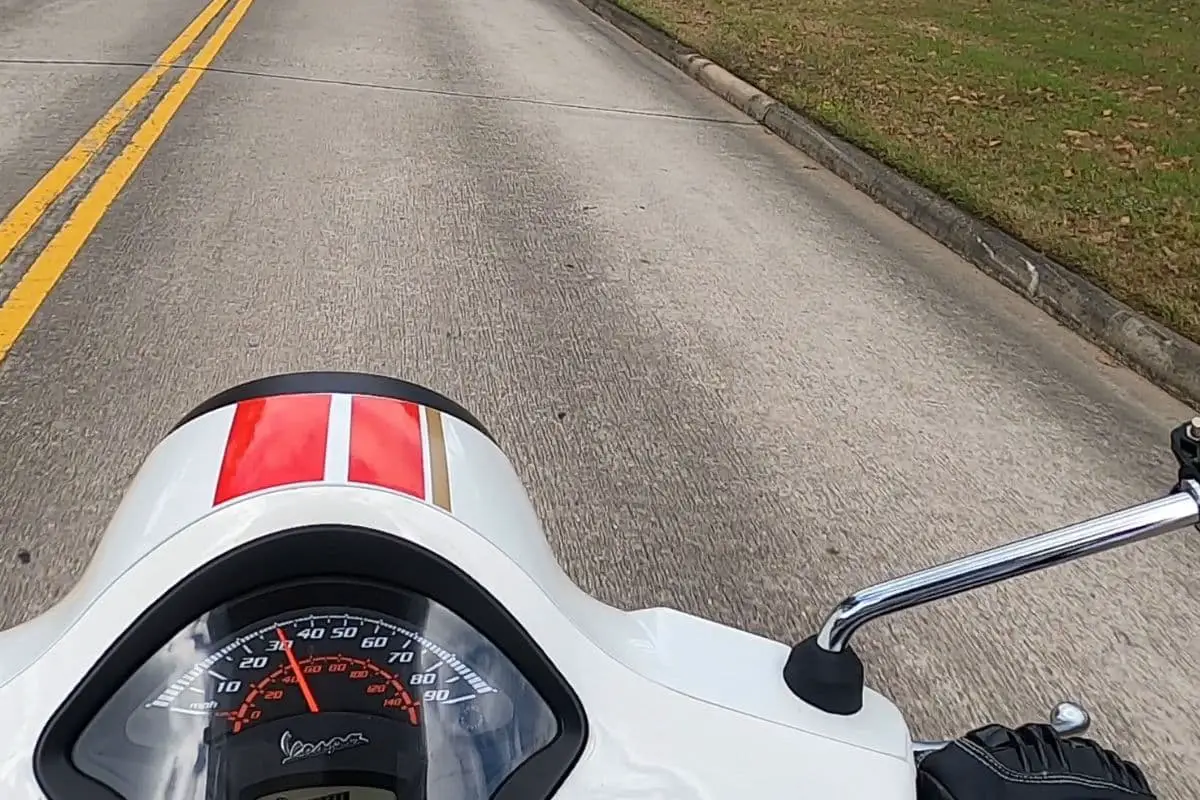 Vespa GTS speedometer and handlebar area on the road