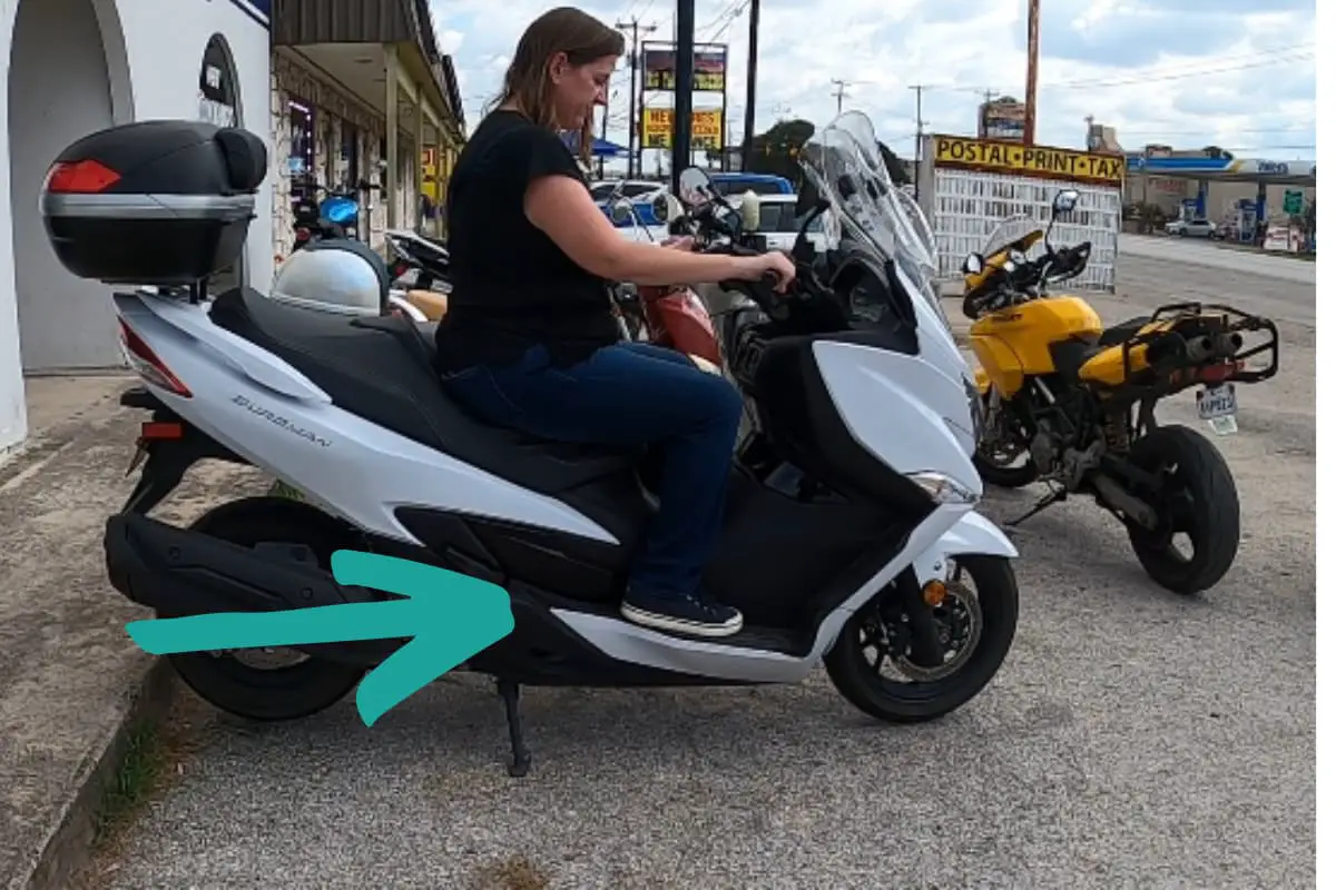 Woman on a Burgman maxi scooter with feet on standard platform