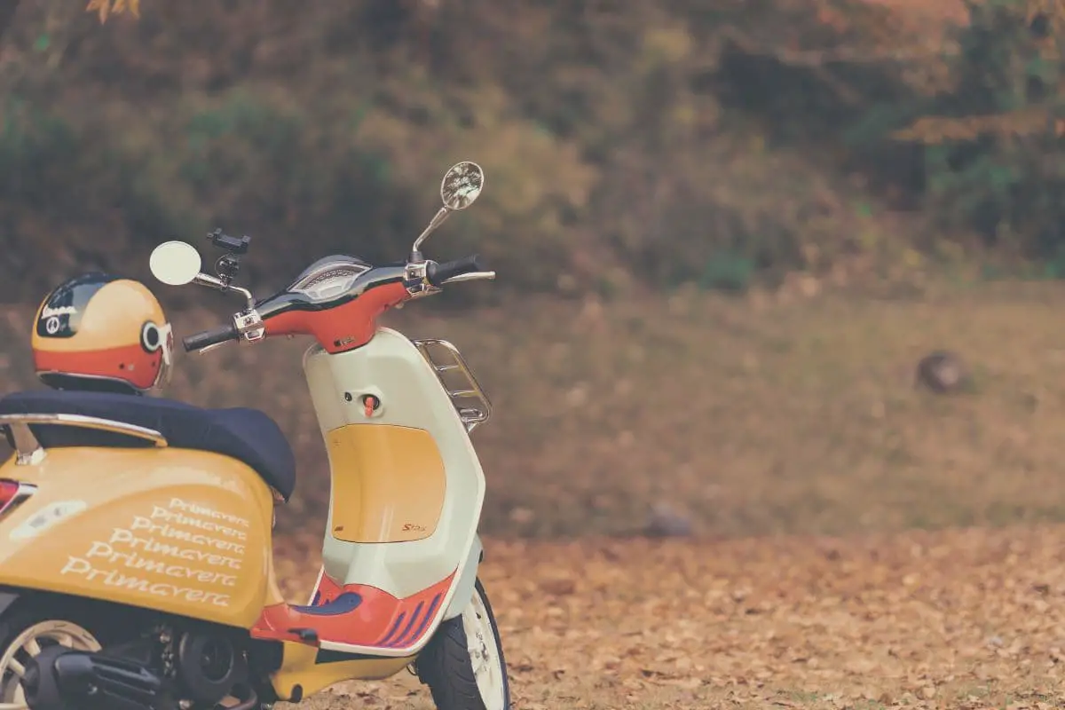 vespa scooter with fall leaves on the ground