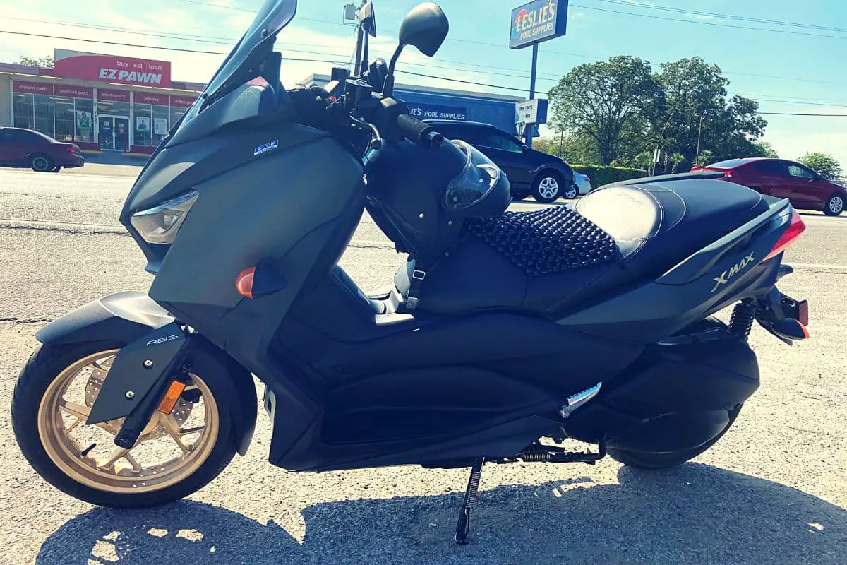 green yamaha xmax in a parking lot